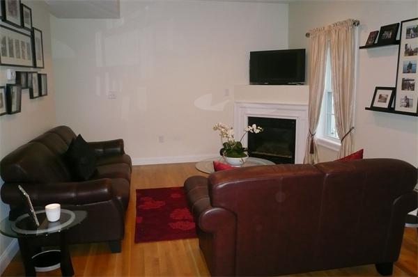 7 C Charles Ridge Road, Unit C Littleton, MA 01460 - Photo 8 of 18 a living room with furniture a flat screen tv and a fireplace