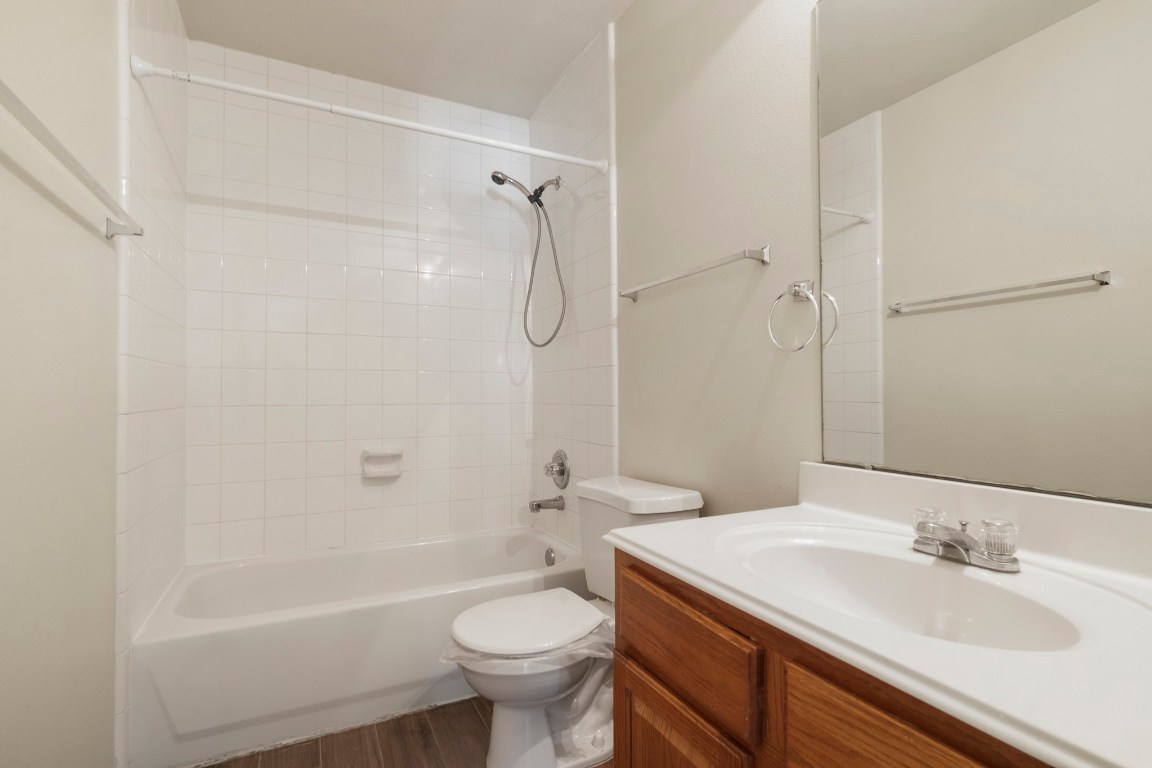 615 Timberstand Lane Spring, TX 77373 - Photo 13 of 19 This inviting guest bathroom features a classic white tub-shower combo, sleek fixtures, and warm wood cabinetry, creating a welcoming and functional space.