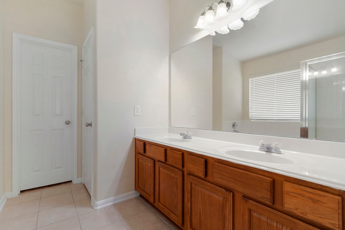 615 Timberstand Lane Spring, TX 77373 - Photo 14 of 19 Experience the elegance of this primary en-suite, featuring a spacious dual-sink vanity, sleek glass-enclosed shower, and abundant natural light for a serene retreat.