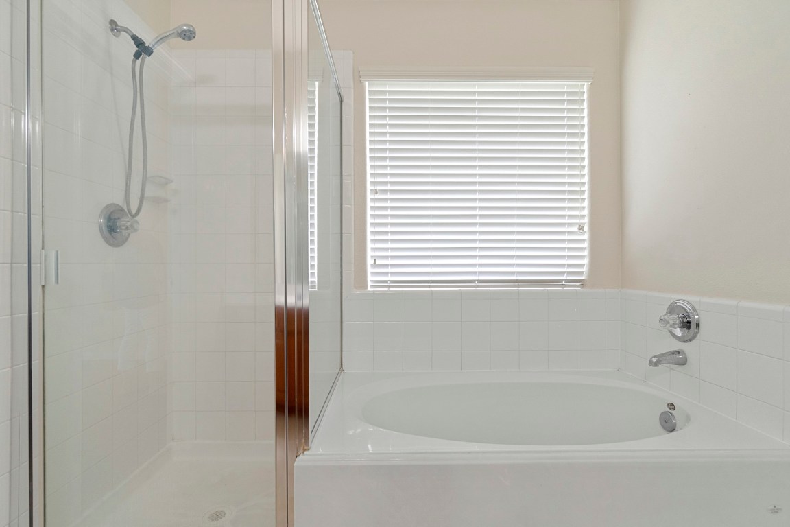 615 Timberstand Lane Spring, TX 77373 - Photo 15 of 19 Indulge in luxury with a serene primary suite featuring a spacious garden bath and a sleek, separate shower for ultimate relaxation.