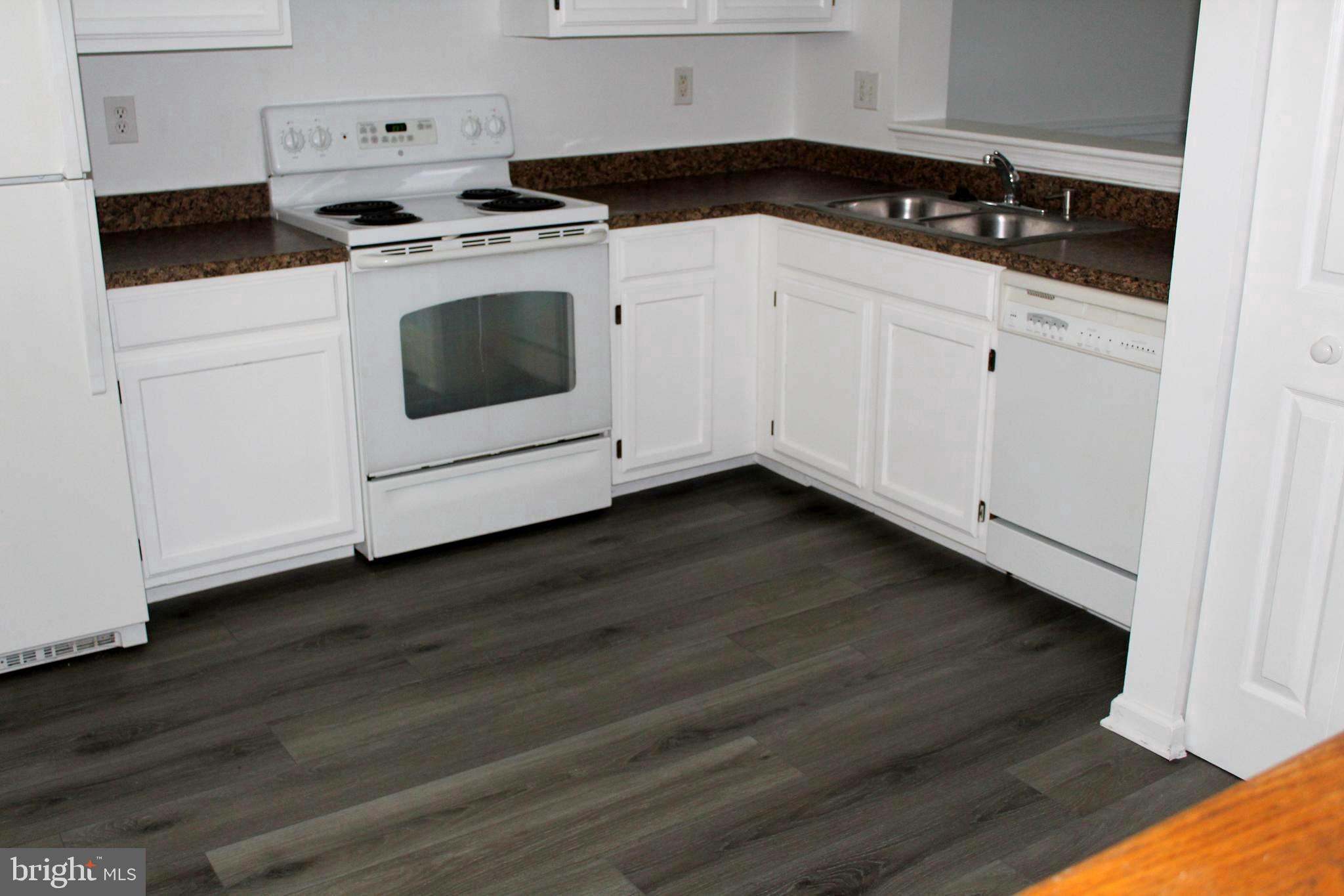 4973 Pintail Court Frederick, MD 21703 - Photo 4 of 28 a kitchen with granite countertop white cabinets and white appliances