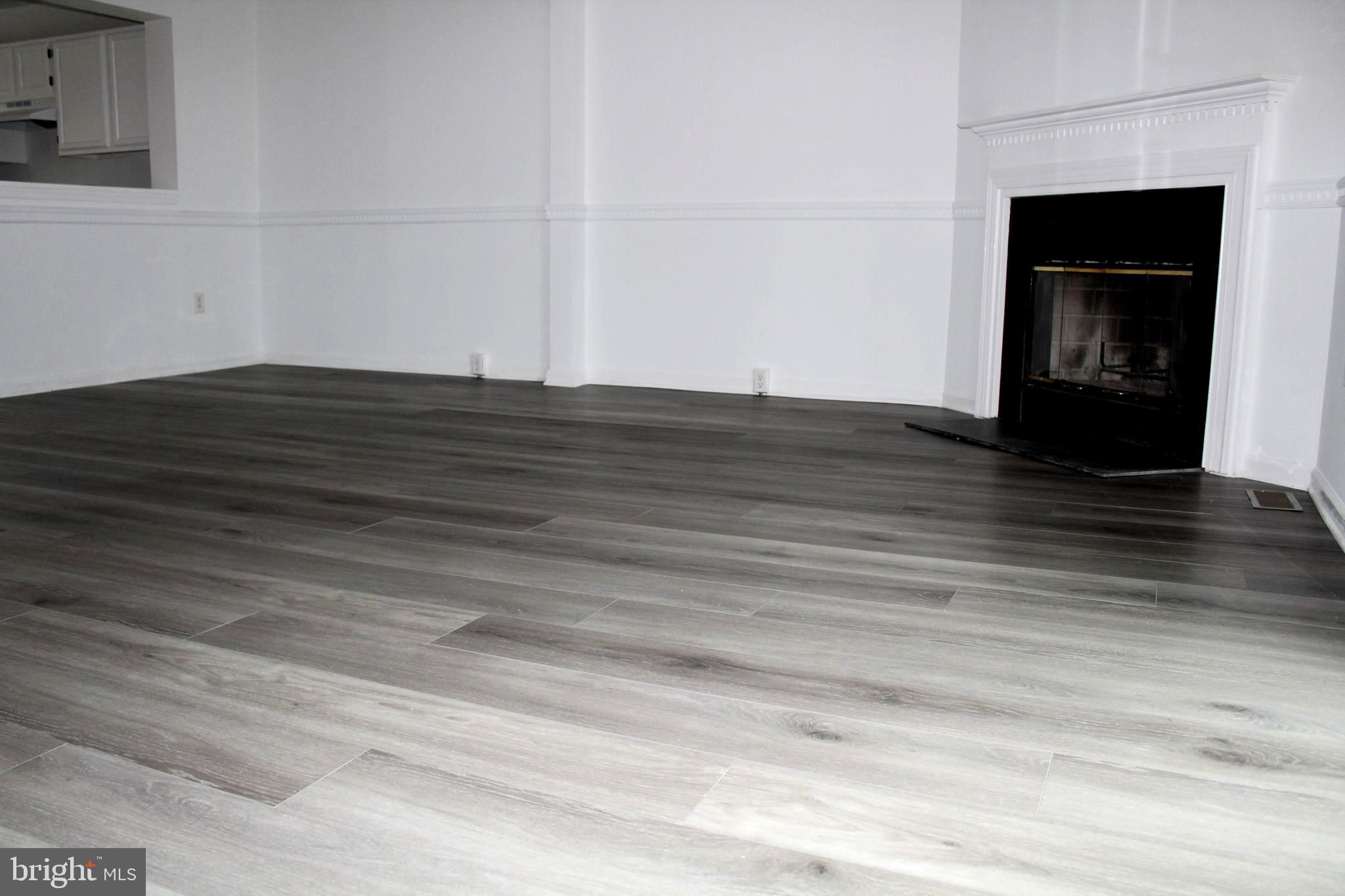 4973 Pintail Court Frederick, MD 21703 - Photo 8 of 28 a view of empty room with wooden floor and fireplace