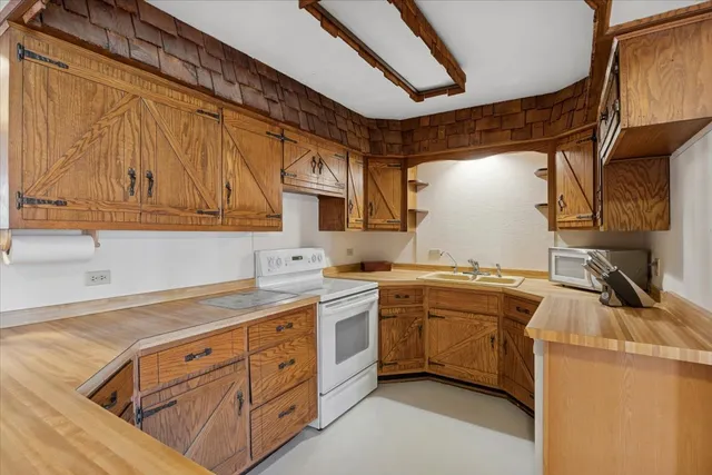 a kitchen with cabinets appliances a sink and a counter top space