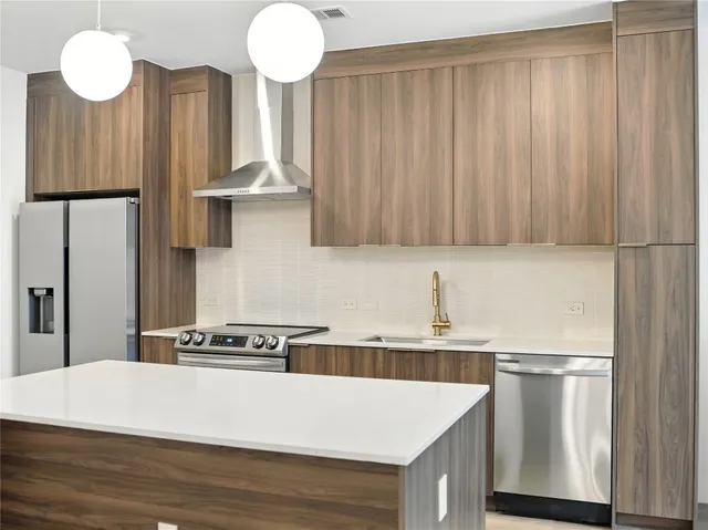 a kitchen with stainless steel appliances a refrigerator and a stove