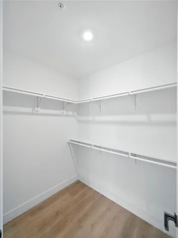 an empty room with wooden floor and a window