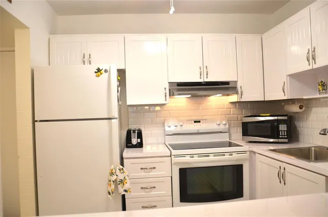 a kitchen with a refrigerator and a stove