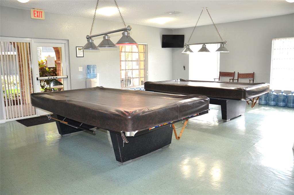 255 South Cypress Road, Unit 342 Pompano Beach, FL 33060 - Photo 17 of 23 a kitchen with stainless steel appliances a table chairs and wooden floor