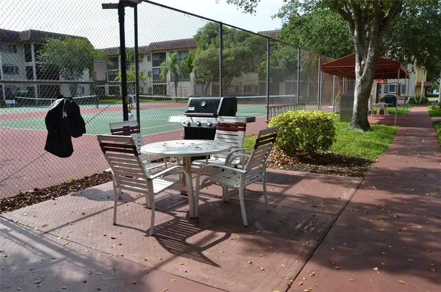 a view of a patio with a table chairs and a backyard