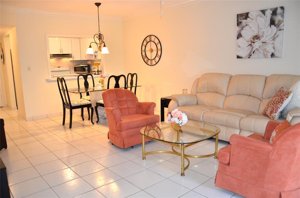 255 South Cypress Road, Unit 342 Pompano Beach, FL 33060 - Photo 4 of 23 a living room with furniture a table and chairs