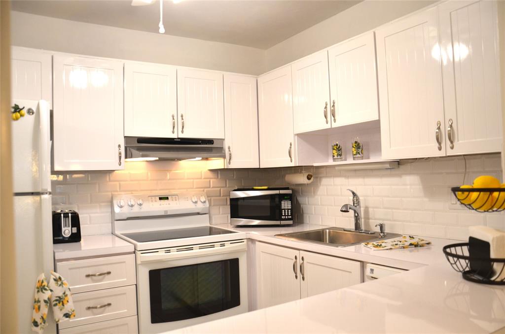 255 South Cypress Road, Unit 342 Pompano Beach, FL 33060 - Photo 6 of 23 a kitchen with cabinets a sink and a stove top oven