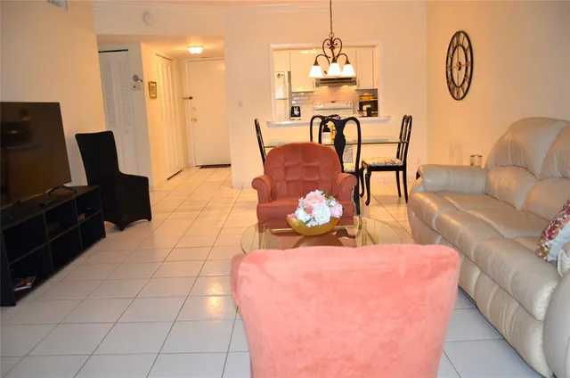 a living room with furniture a flat screen tv and a table