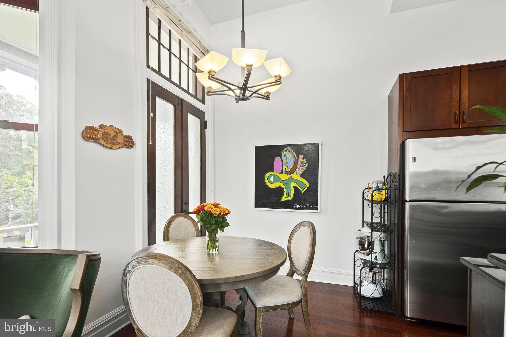 9610 Dewitt Drive, Unit PH204 Silver Spring, MD 20910 - Photo 14 of 42 a dining room with furniture a chandelier and wooden floor