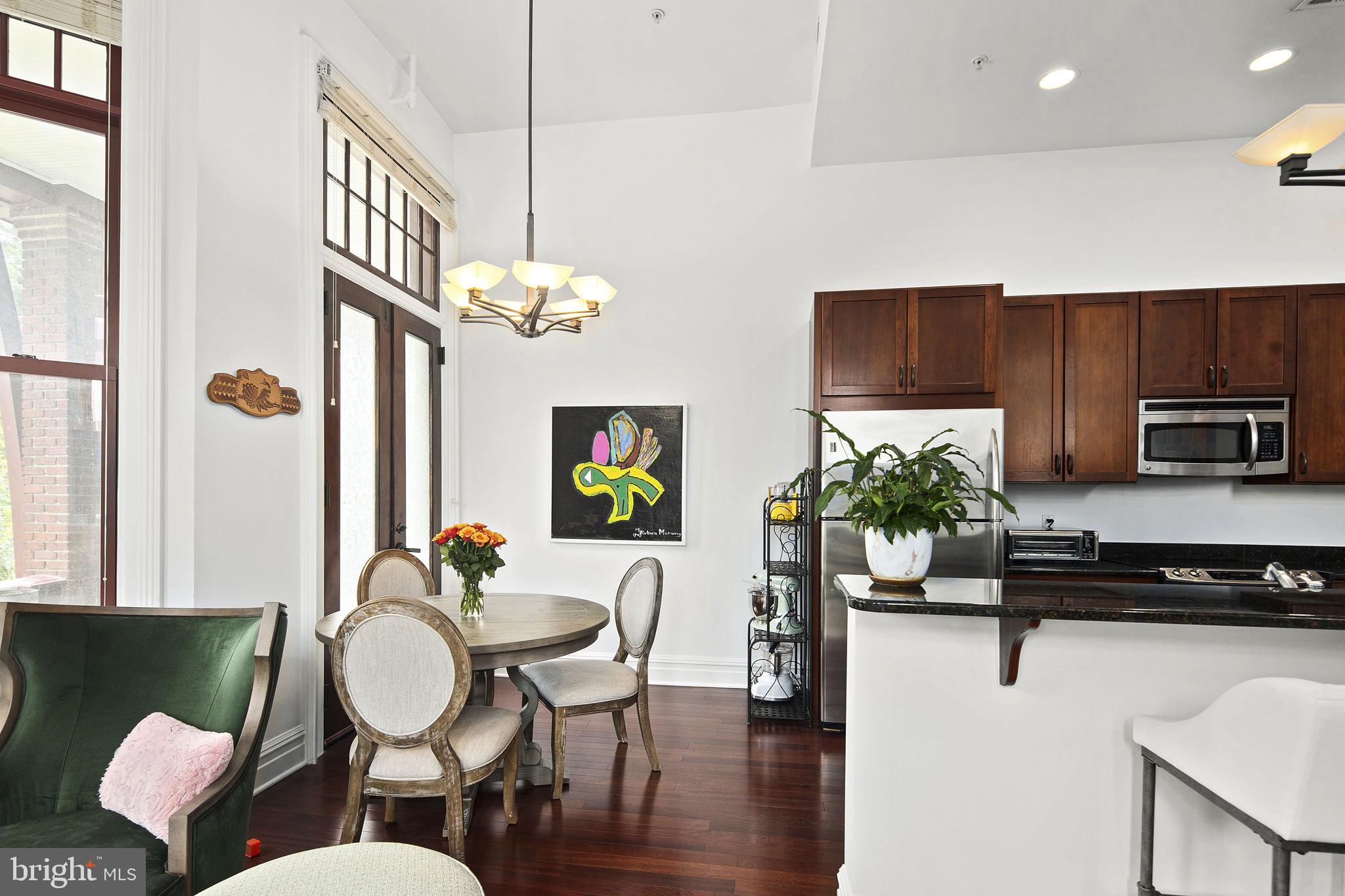 9610 Dewitt Drive, Unit PH204 Silver Spring, MD 20910 - Photo 15 of 42 a dining room with furniture a chandelier and wooden floor