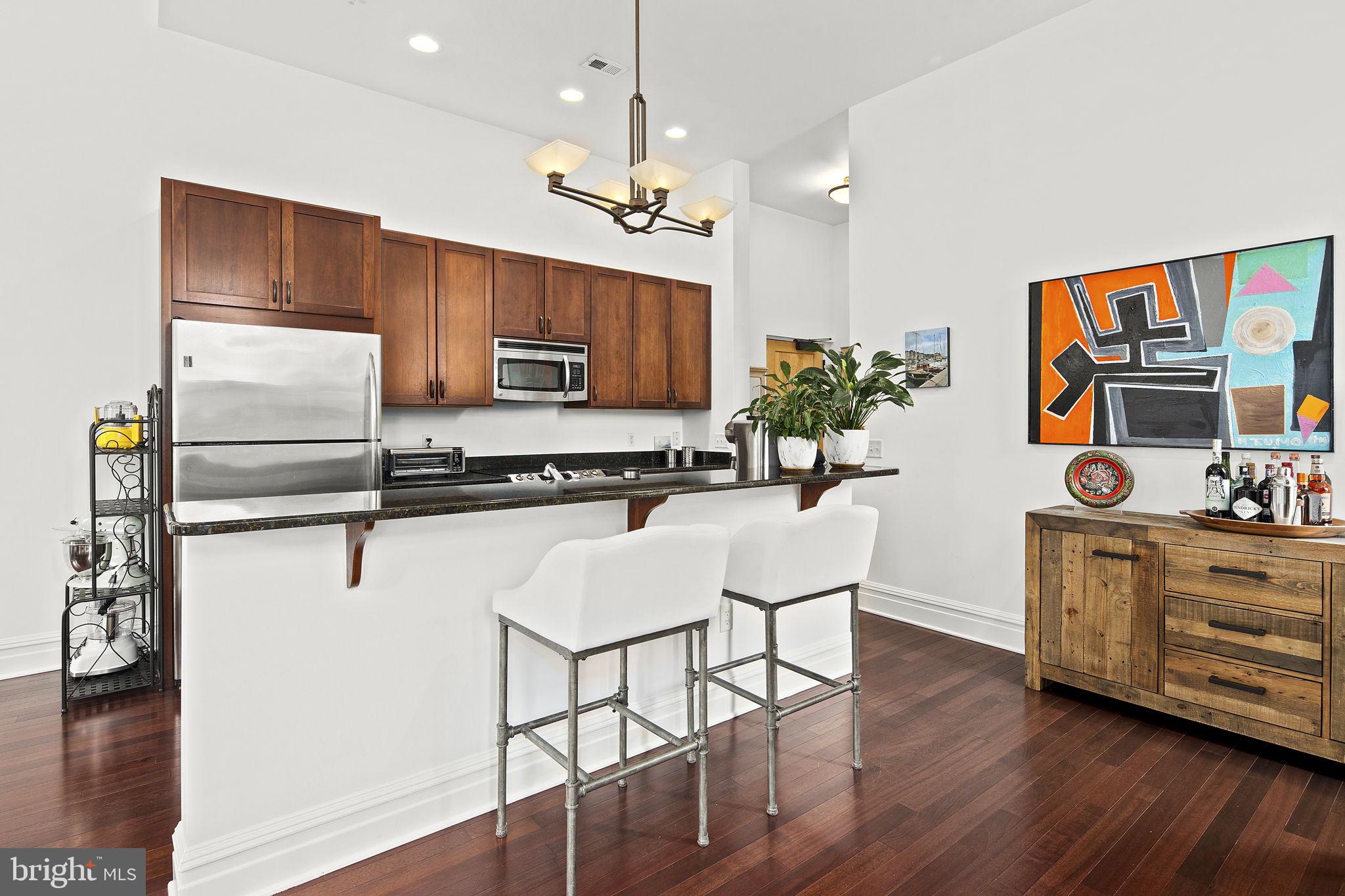9610 Dewitt Drive, Unit PH204 Silver Spring, MD 20910 - Photo 21 of 42 a kitchen with stainless steel appliances kitchen island granite countertop a stove a sink and a refrigerator