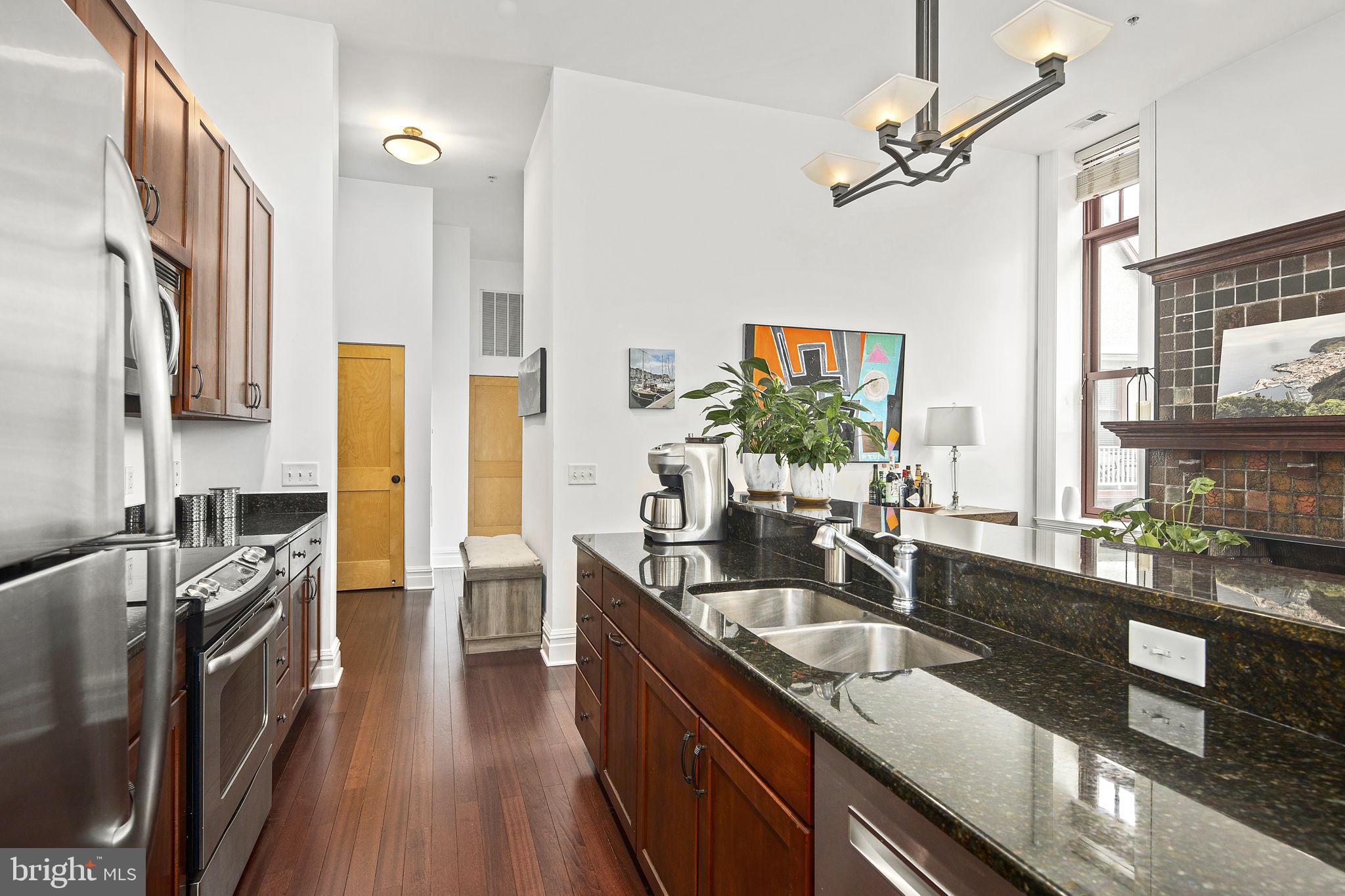 9610 Dewitt Drive, Unit PH204 Silver Spring, MD 20910 - Photo 23 of 42 a kitchen with stainless steel appliances granite countertop a sink stove and refrigerator
