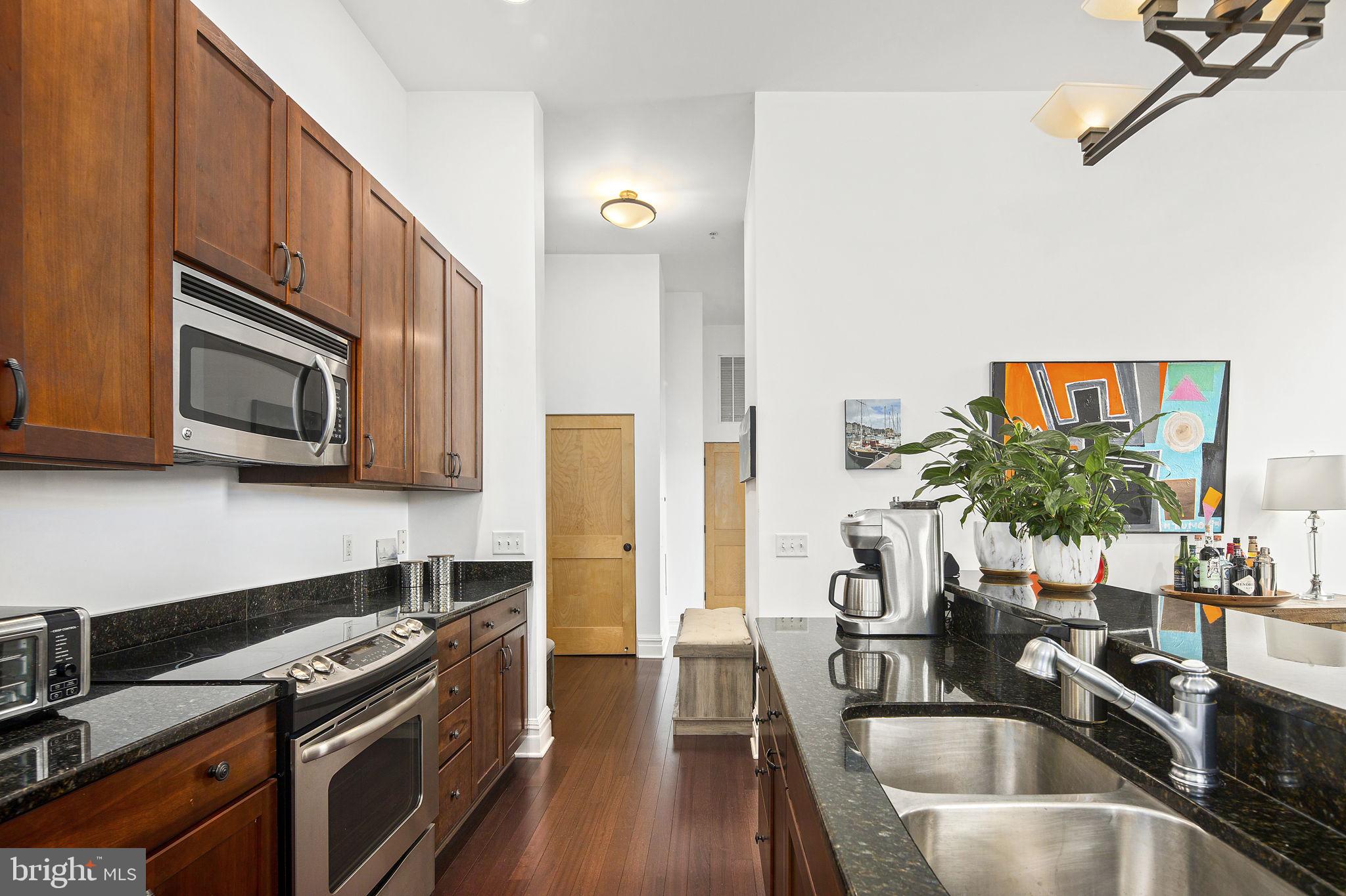 9610 Dewitt Drive, Unit PH204 Silver Spring, MD 20910 - Photo 24 of 42 a kitchen with stainless steel appliances a sink a stove top oven a counter space and cabinets