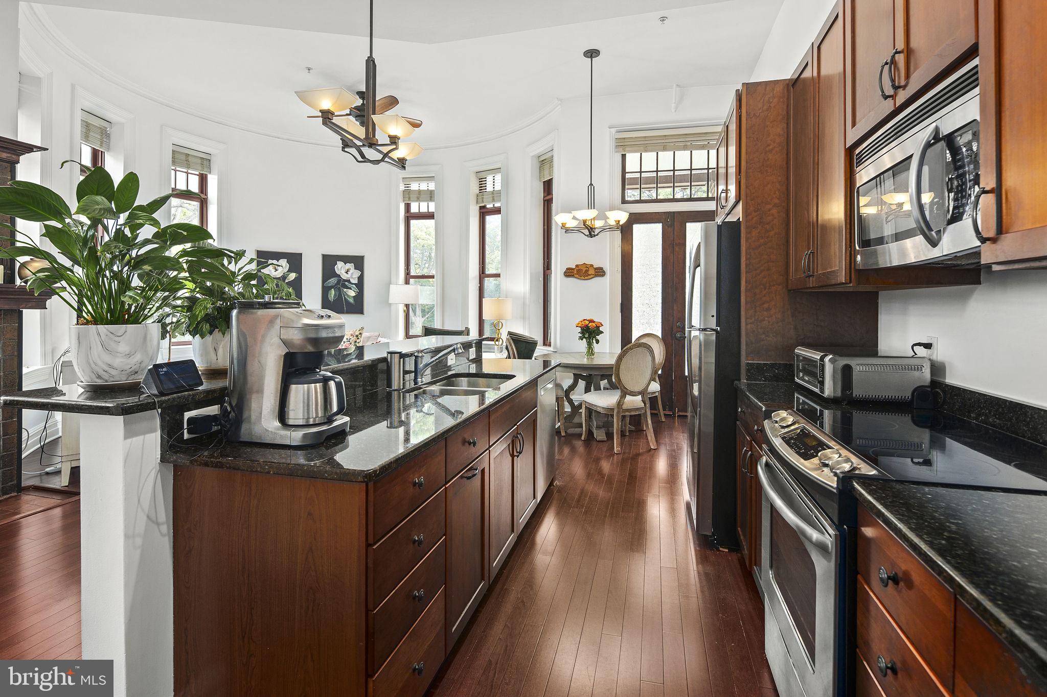 9610 Dewitt Drive, Unit PH204 Silver Spring, MD 20910 - Photo 25 of 42 a kitchen with stainless steel appliances granite countertop a sink a stove and a wooden floors