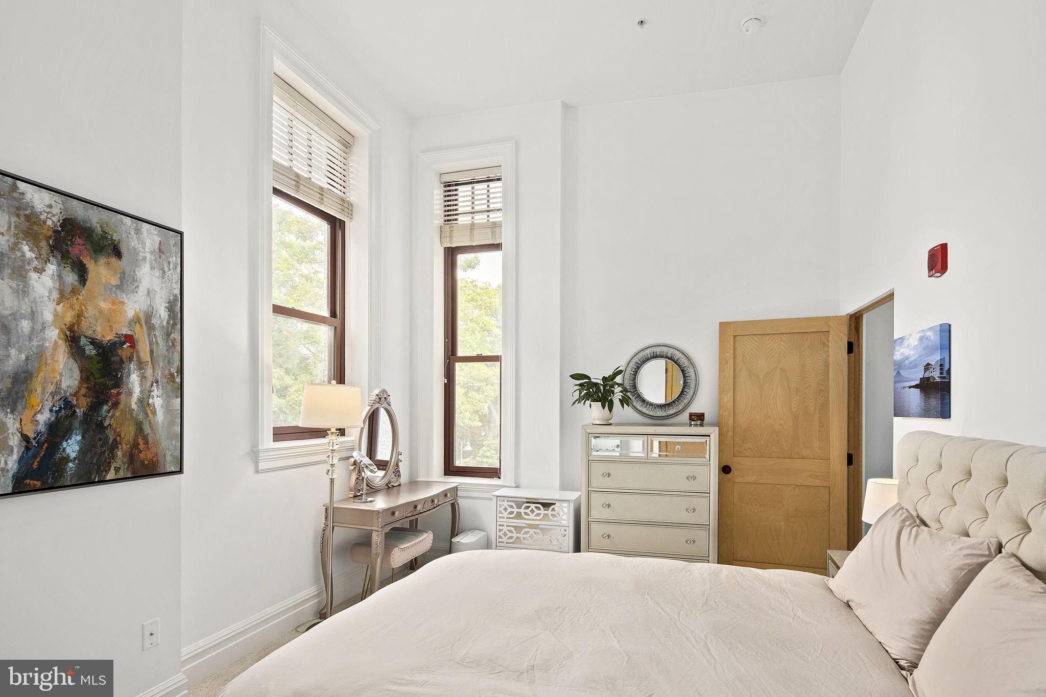 9610 Dewitt Drive, Unit PH204 Silver Spring, MD 20910 - Photo 33 of 42 a bedroom with a bed and a painting on the wall