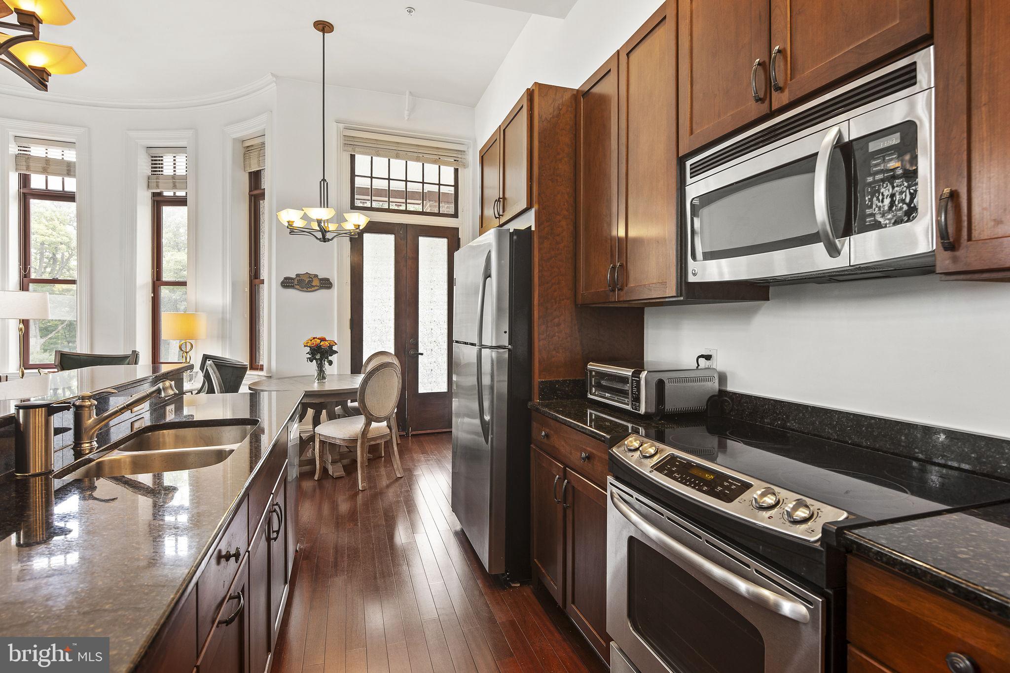9610 Dewitt Drive, Unit PH204 Silver Spring, MD 20910 - Photo 5 of 42 a kitchen with a stove a sink and wooden cabinets