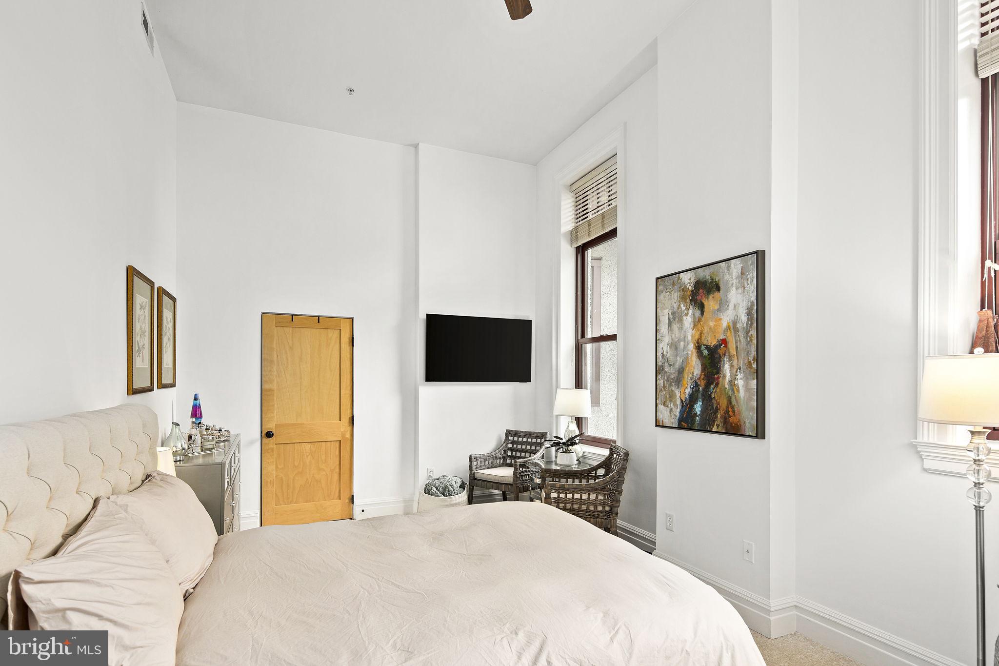 9610 Dewitt Drive, Unit PH204 Silver Spring, MD 20910 - Photo 9 of 42 a bedroom with a bed and a flat screen tv