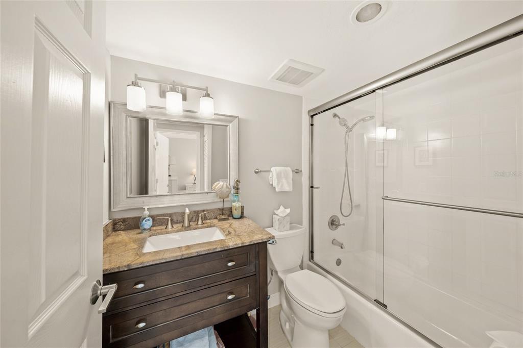 1256 Riegels Landing Drive Sarasota, FL 34242 - Photo 12 of 40 a bathroom with a toilet a sink a mirror a shower a vanity and window