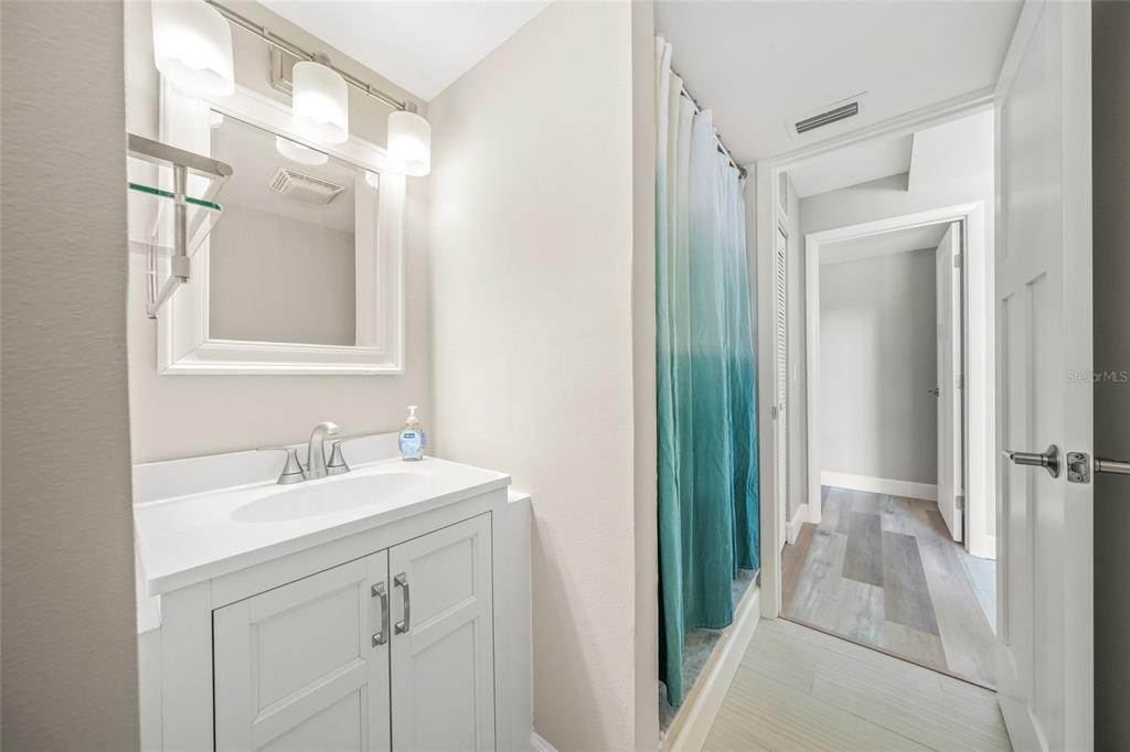 1256 Riegels Landing Drive Sarasota, FL 34242 - Photo 22 of 40 a bathroom with a sink a mirror and a shower