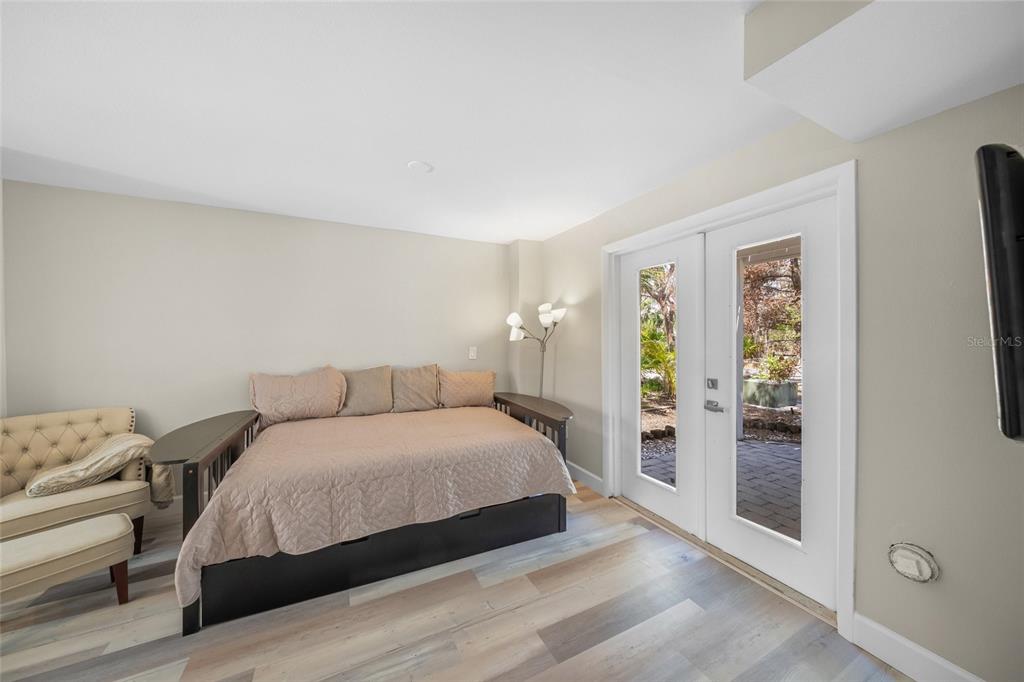 1256 Riegels Landing Drive Sarasota, FL 34242 - Photo 23 of 40 a bedroom with a large bed and a chandelier