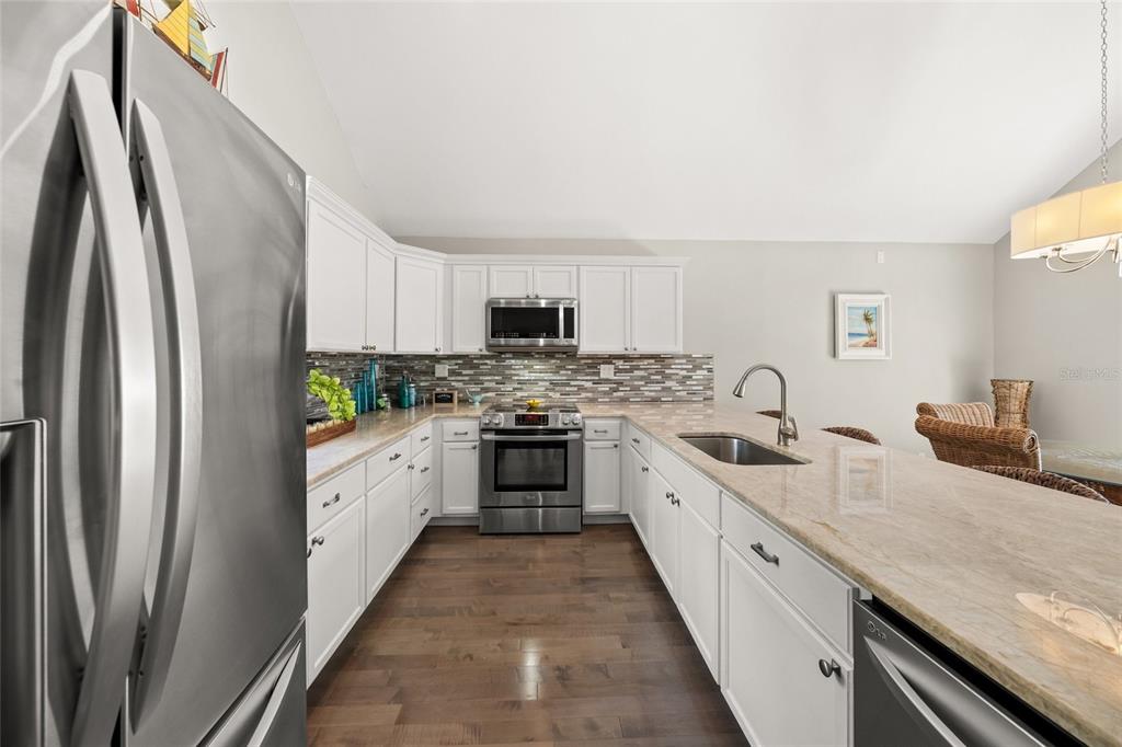 1256 Riegels Landing Drive Sarasota, FL 34242 - Photo 7 of 40 a kitchen with stainless steel appliances granite countertop a refrigerator sink and stove