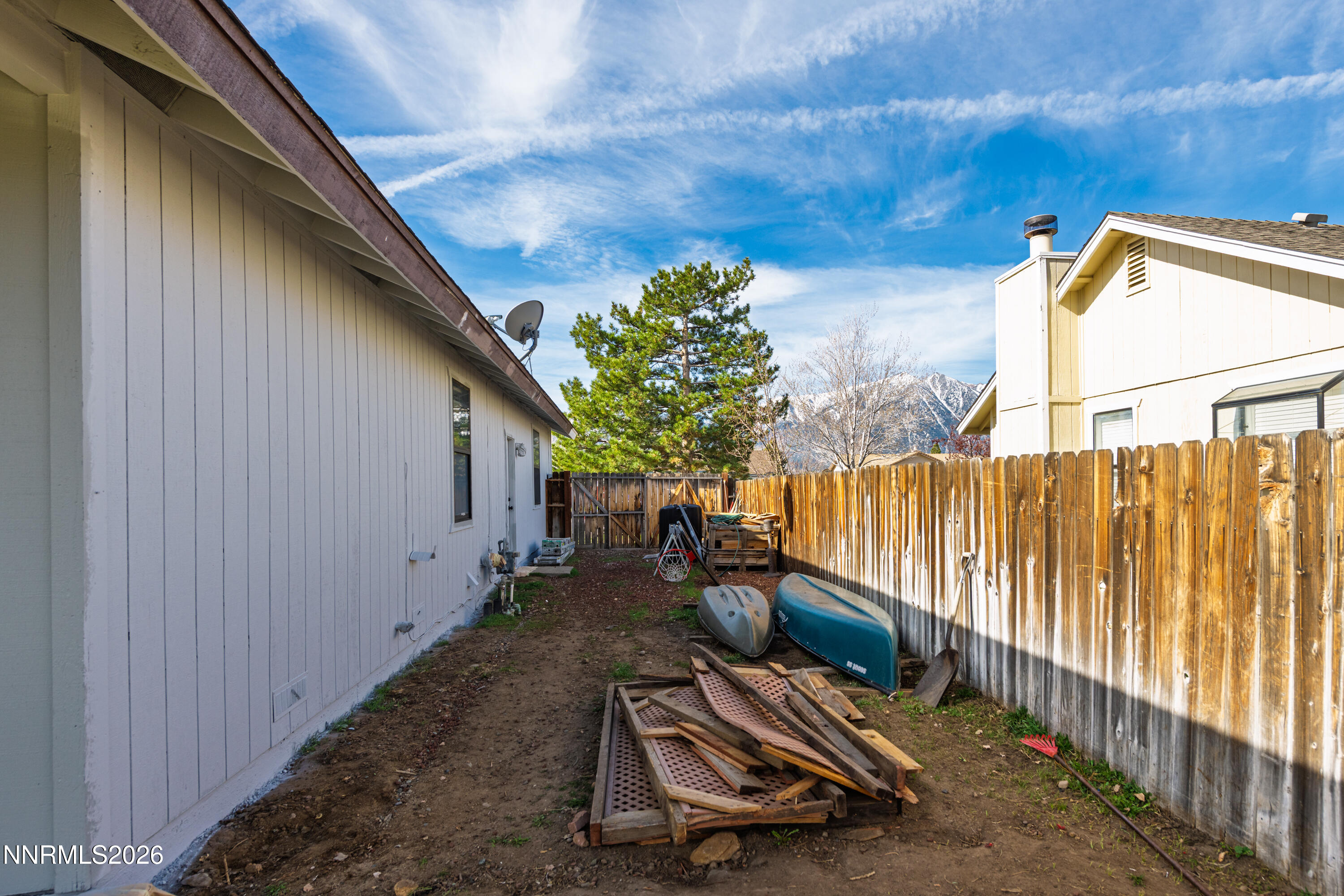 1352 Leonard Road Gardnerville, NV 89460 - Photo 19 of 23 a view of backyard with wooden fence and trees