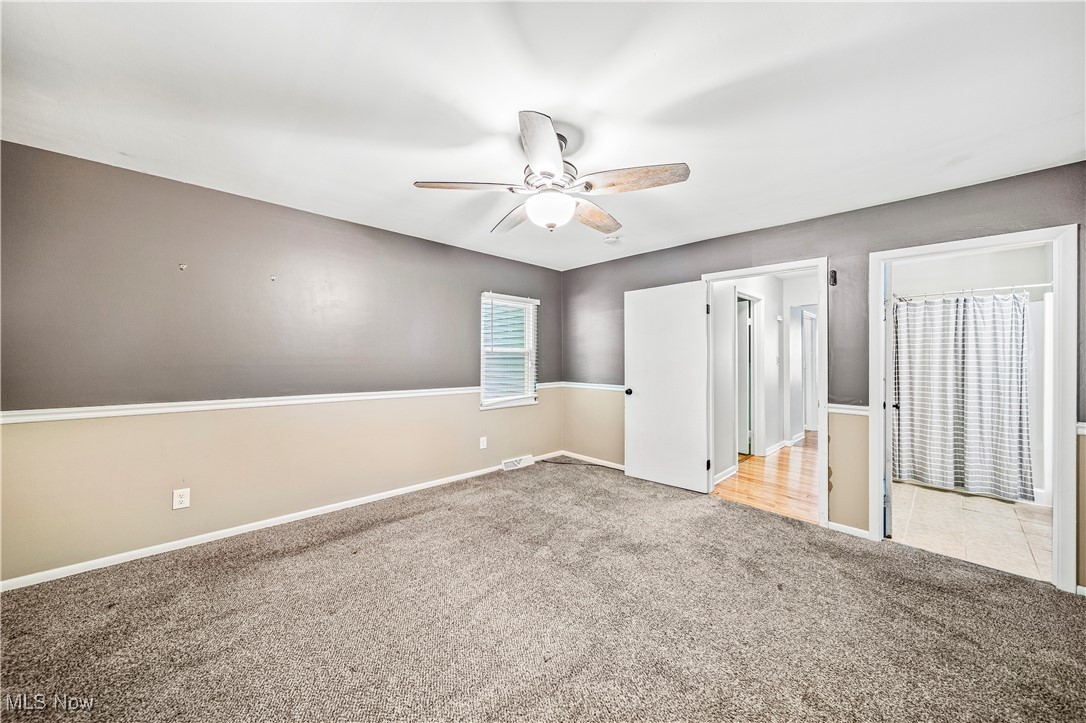 1796 Lander Road Mayfield Heights, OH 44124 - Photo 18 of 39 Unfurnished bedroom featuring light carpet, ceiling fan, and ensuite bathroom