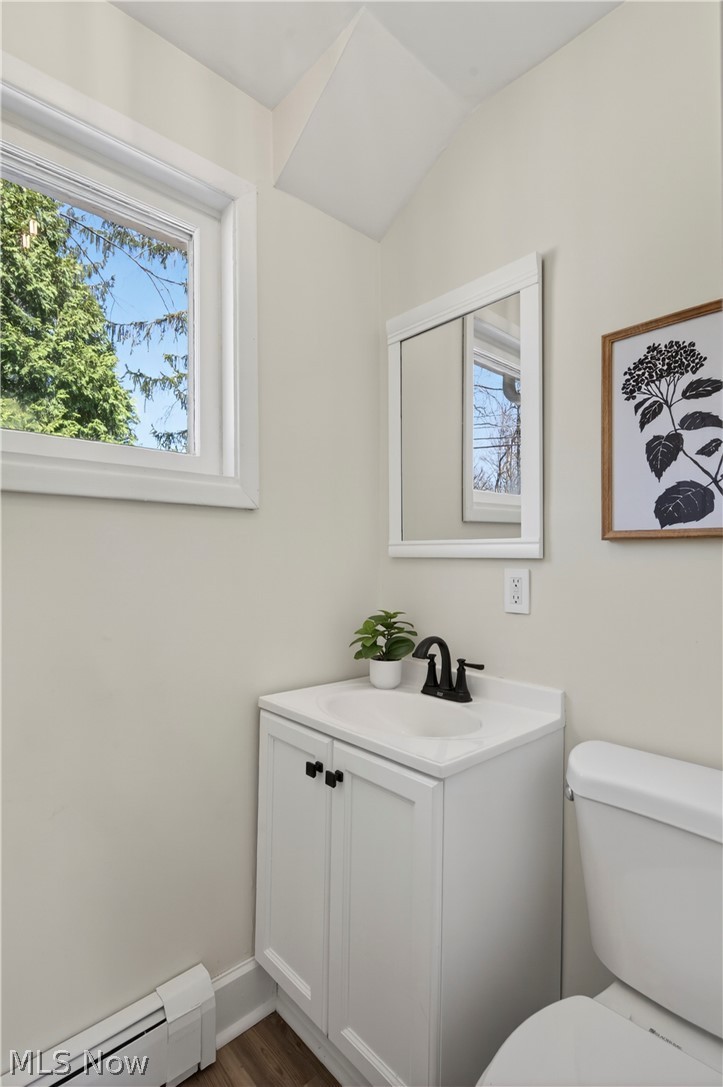 14939 Caves Road Novelty, OH 44072 - Photo 16 of 42 Half bath featuring a baseboard heating unit, vanity, and dark wood-type flooring