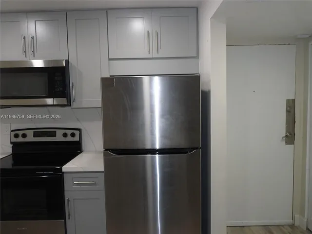 a metallic refrigerator freezer sitting in a kitchen