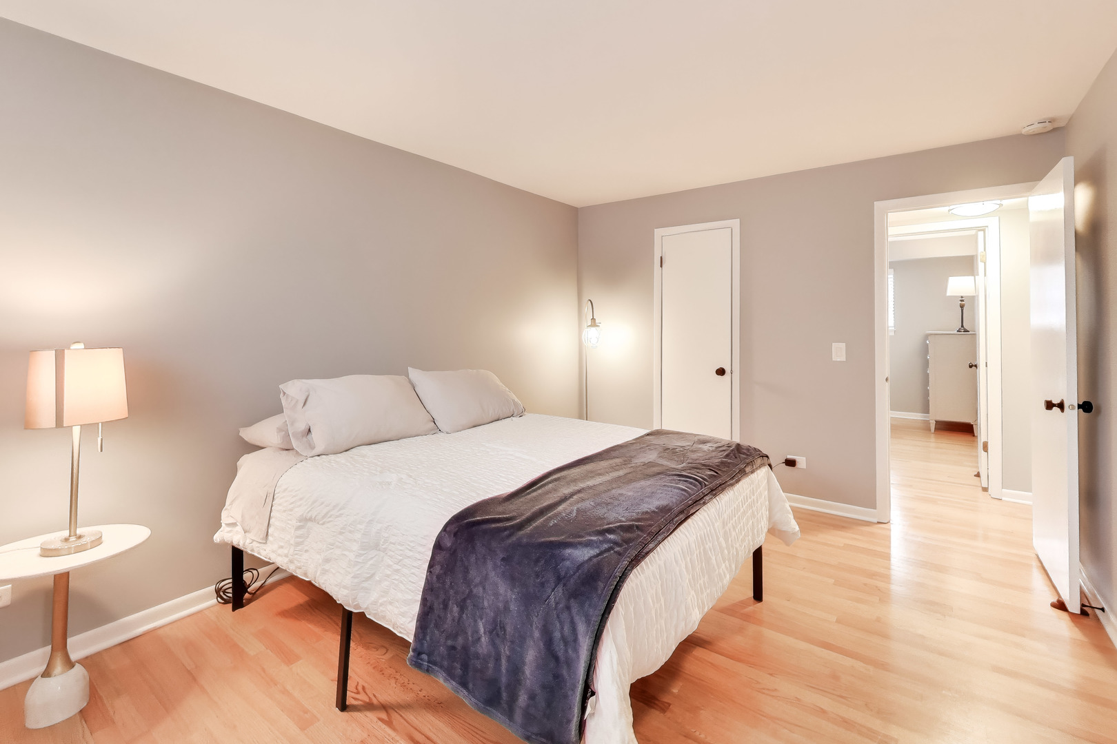 6820 West Raven Street, Unit 1B Chicago, IL 60631 - Photo 15 of 25 a spacious bedroom with a bed and a lamp