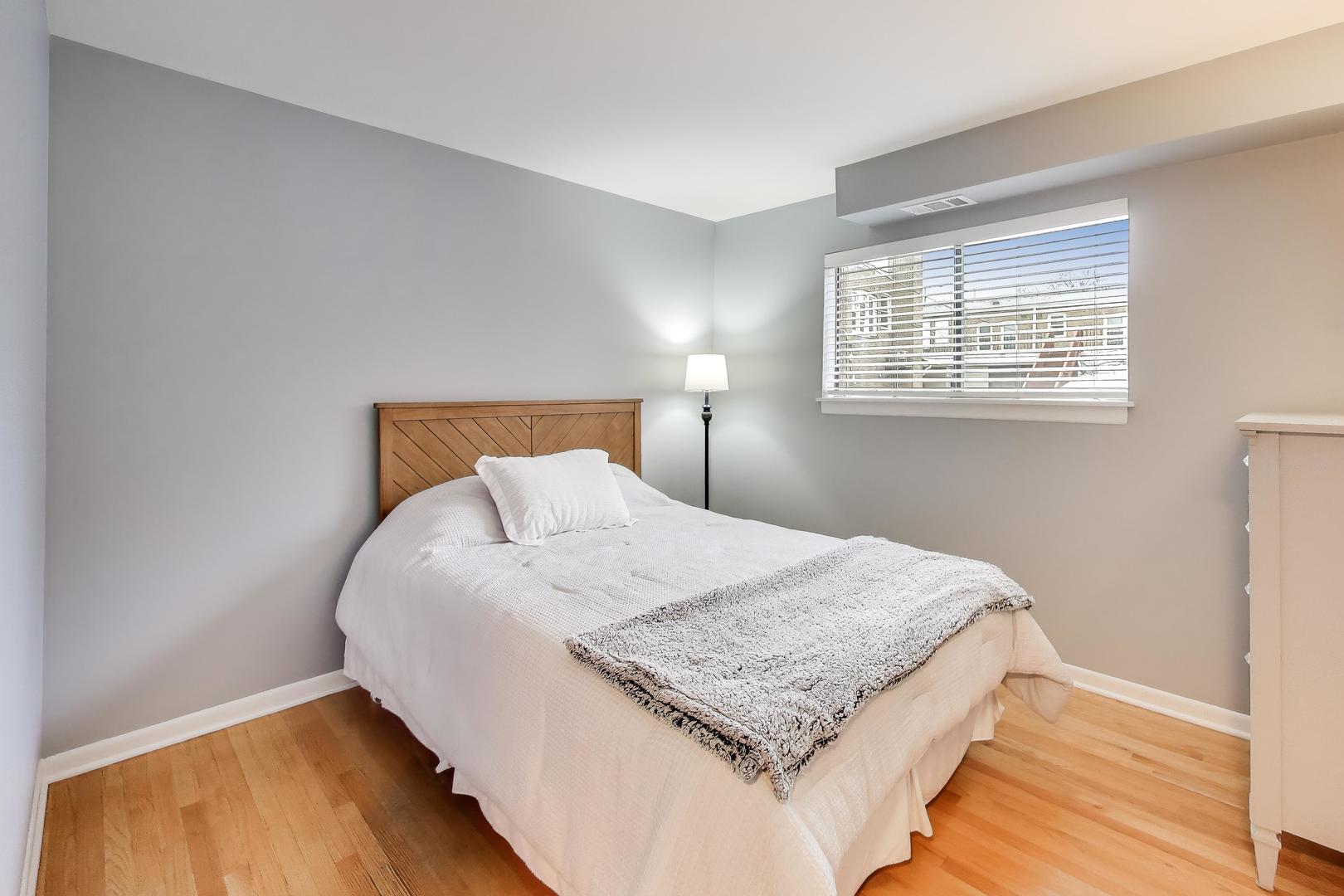 6820 West Raven Street, Unit 1B Chicago, IL 60631 - Photo 17 of 25 a bed sitting in a bedroom next to a window