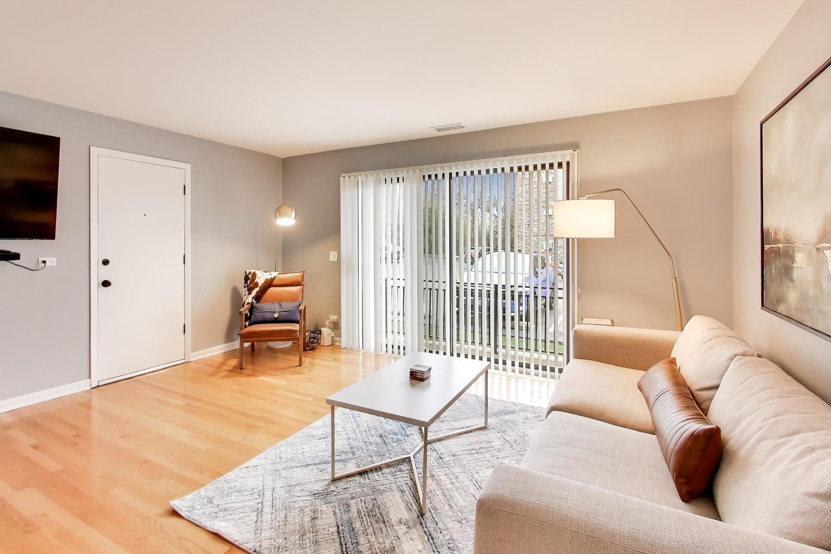 6820 West Raven Street, Unit 1B Chicago, IL 60631 - Photo 8 of 25 a living room with furniture and a flat screen tv