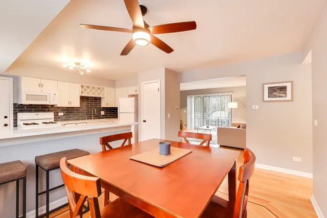a dining room with stainless steel appliances kitchen island granite countertop a dining table and chairs