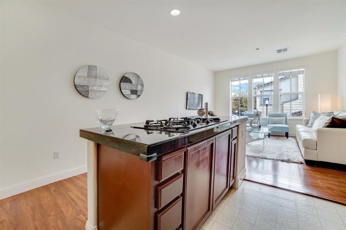49030 Meadowfaire Common Fremont, CA 94539 - Photo 17 of 52 a kitchen with a sink and a stove with wooden floor