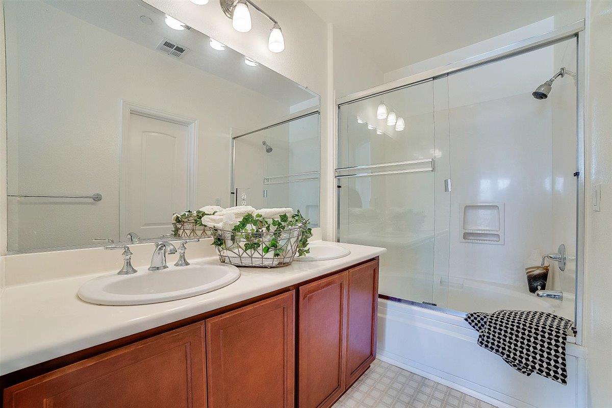 49030 Meadowfaire Common Fremont, CA 94539 - Photo 28 of 52 a bathroom with a sink double vanity granite tub shower and a mirror