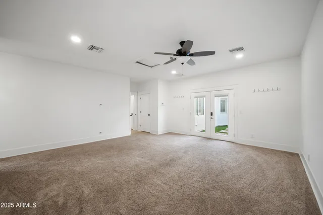an empty room with a ceiling fan and window