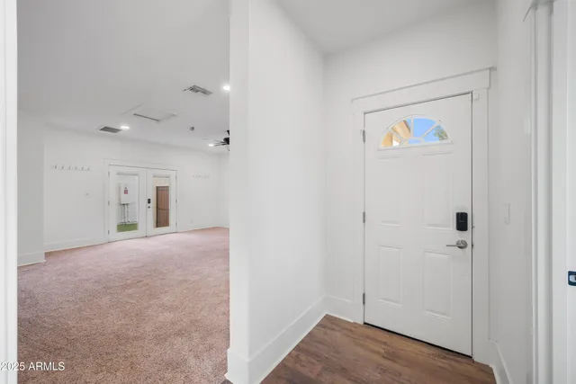 a view of a hallway with wooden floor and closet
