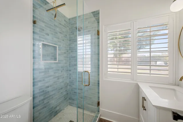 a bathroom with a sink a shower and a window