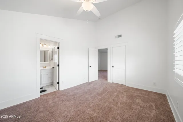 a view of a big room with windows and chandelier fan