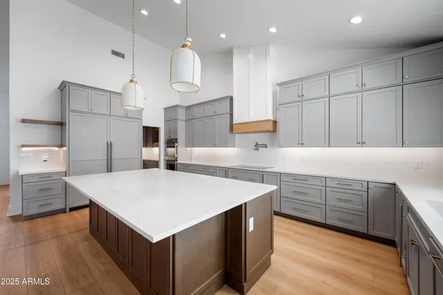 a kitchen that has a lot of cabinets and wooden floor