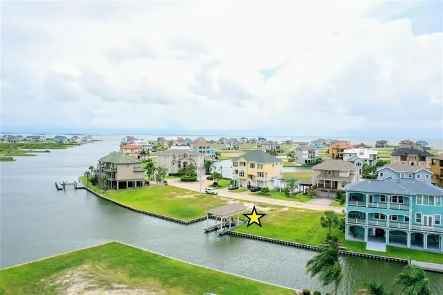 an aerial view of a house with a garden and lake view