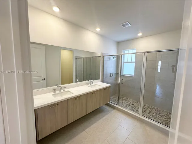 a bathroom with a mirror a shower and a sink