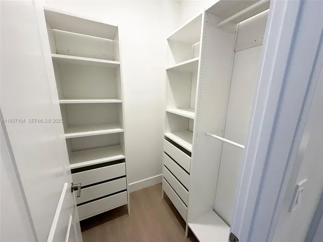 a view of walk in closet with empty racks