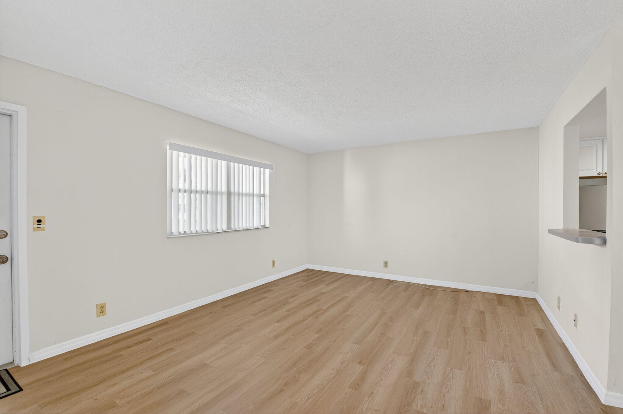 51 Flanders B Delray Beach, FL 33484 - Photo 6 of 42 an empty room with wooden floor and windows