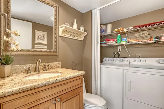 a bathroom with a granite countertop toilet sink and mirror