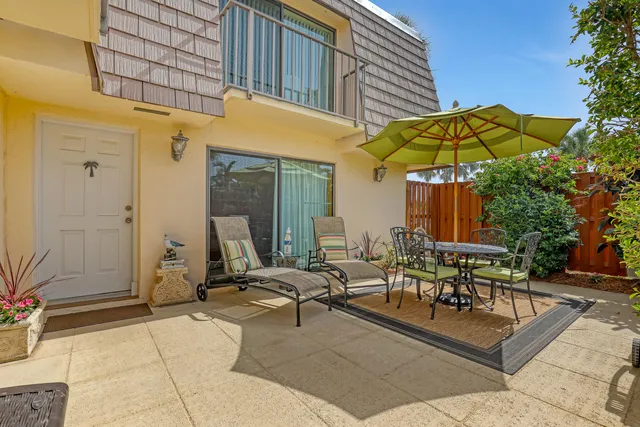 a view of a patio with a table and chairs under an umbrella