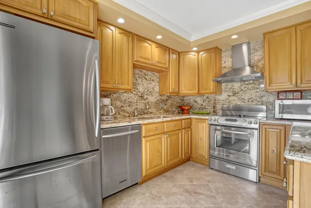 a kitchen with stainless steel appliances granite countertop a refrigerator and a stove